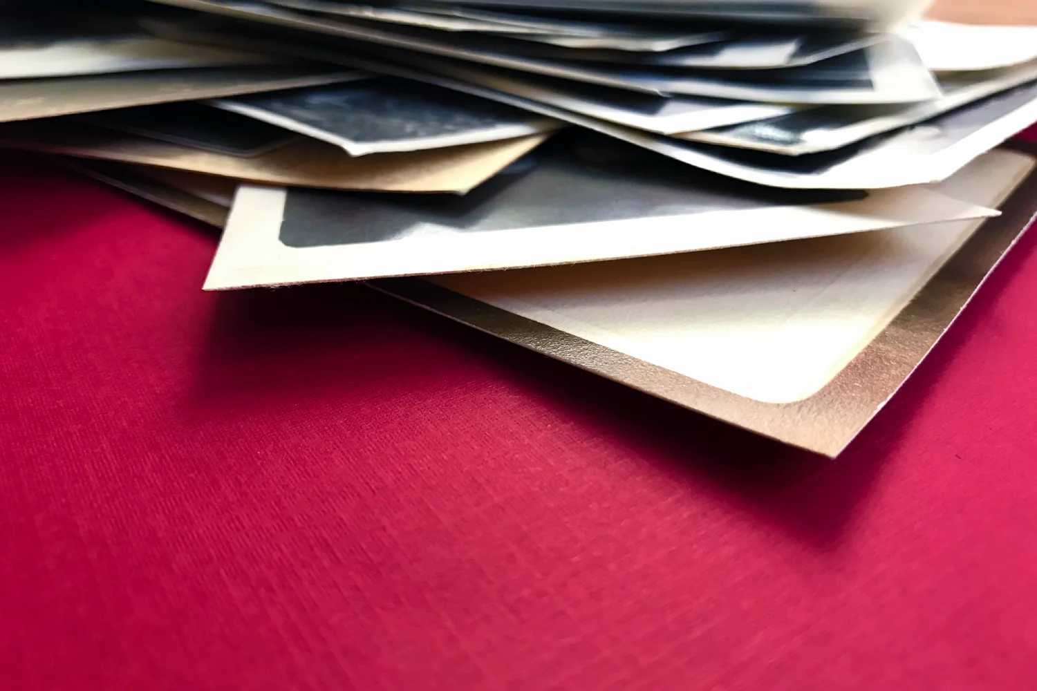 A pile of envelopes stacked on a red surface.