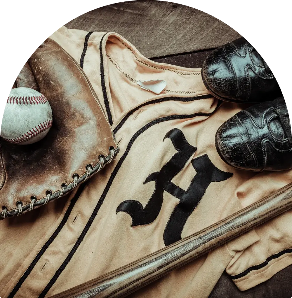 Vintage baseball equipment including a glove, ball, and jersey with an H.