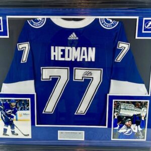 A framed hockey jersey with the name Hedman and number 77.