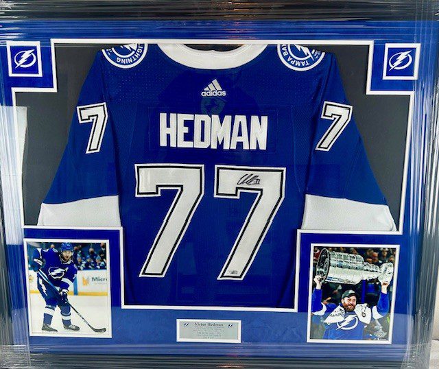 A framed hockey jersey with the name Hedman and number 77.