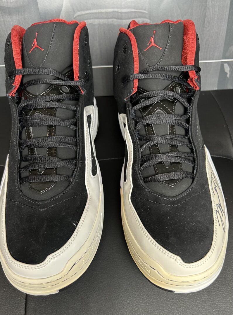 Black and red basketball shoes on display.
