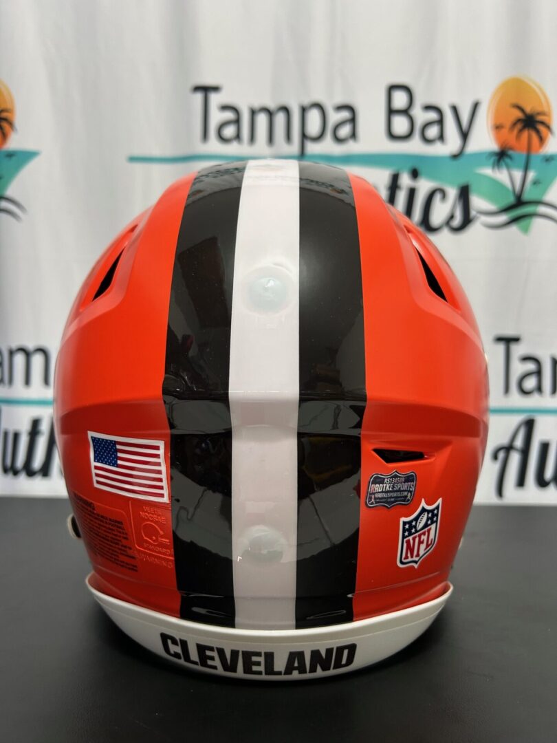Rear view of a red helmet with stripes and stickers.