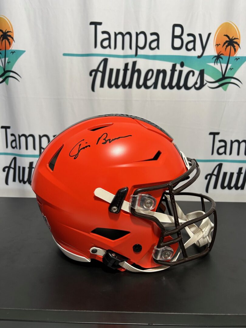 Orange football helmet with autographs on display.