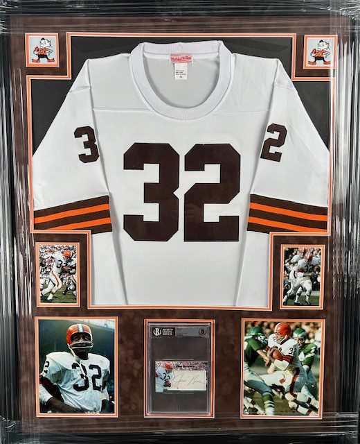A framed football jersey number 32 with commemorative photos and plaque.