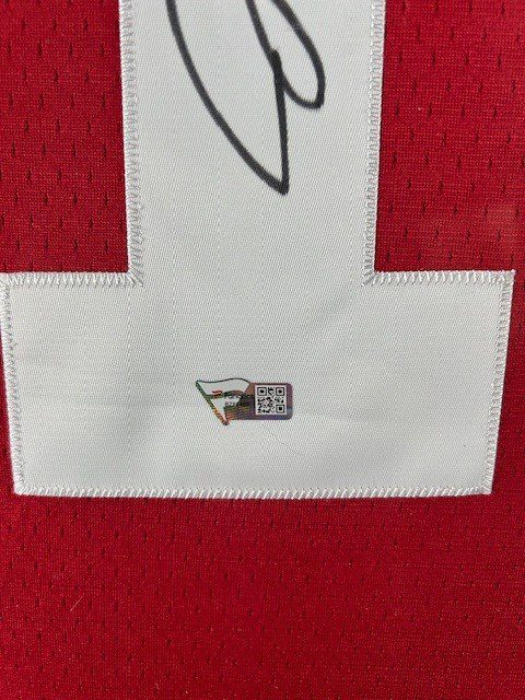 A red sports jersey with a white number patch and a small embroidered logo.