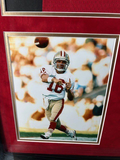 Football player in white and red uniform throwing a pass on the field.