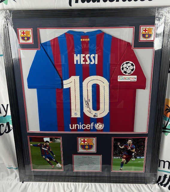 Framed Lionel Messi Barcelona jersey with memorabilia.