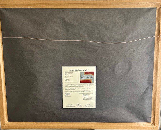 A black padded envelope with a shipping label on a wooden surface.