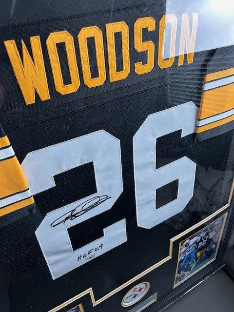 Framed football jersey with autograph and photo.