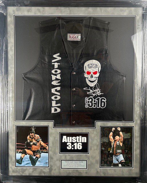 A black vest with Stone Cold theme and skull design in a display case.