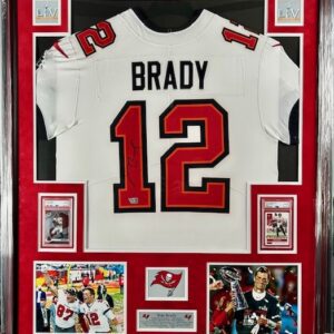 Framed Tom Brady jersey with memorabilia.
