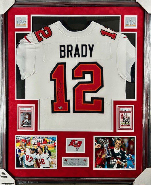 Framed Tom Brady jersey with memorabilia.
