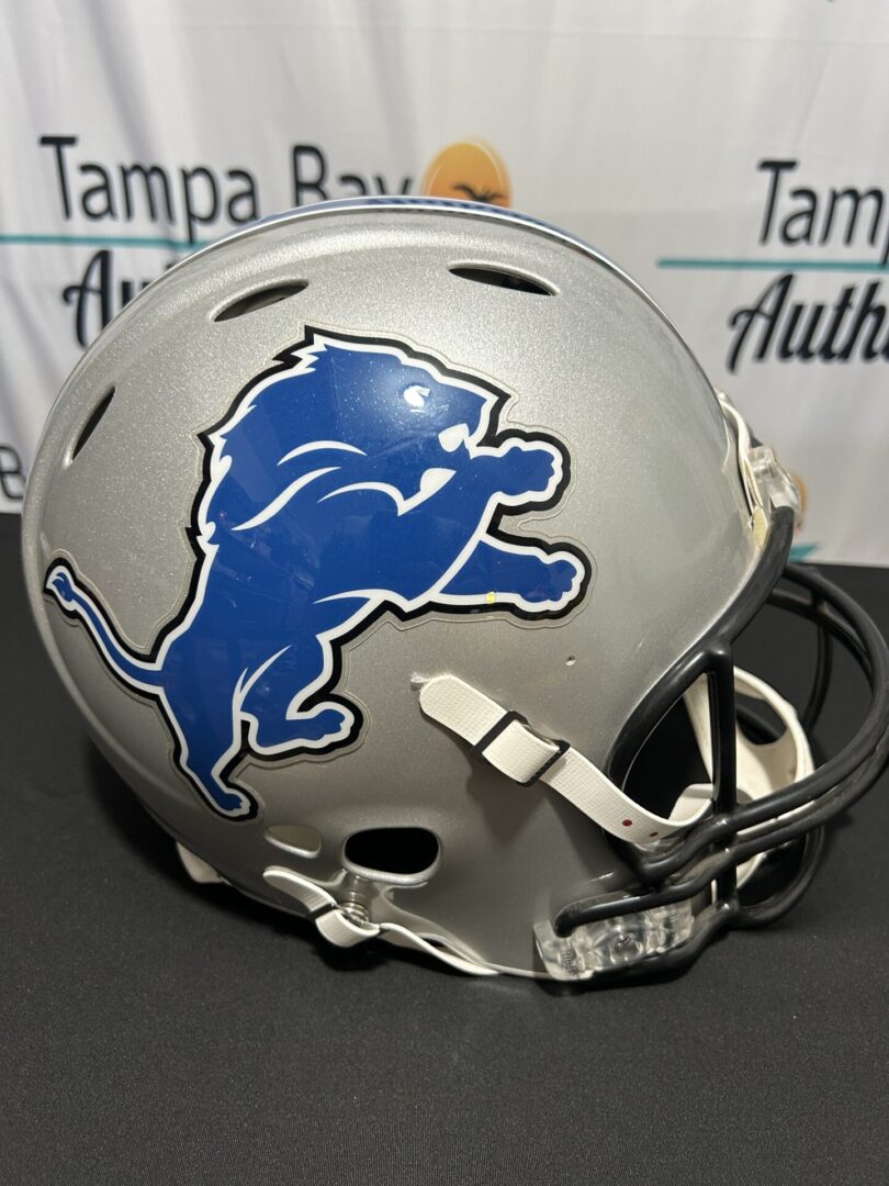 Silver football helmet with blue lion logo.