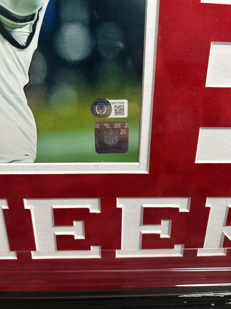 Framed sports memorabilia with authentication stickers.