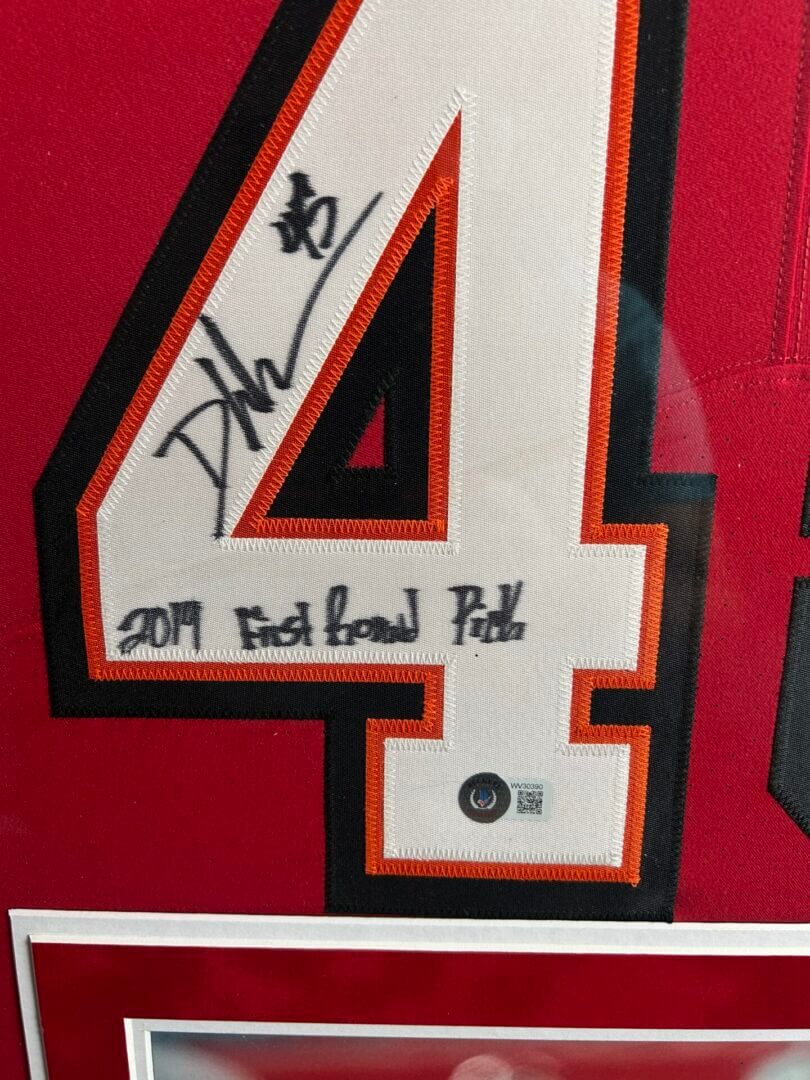 Signed sports jersey number in red frame.