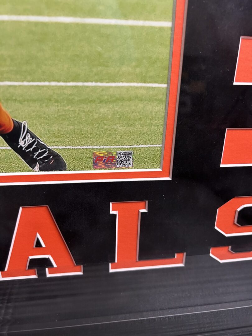 Framed sports photo with visible QR code.